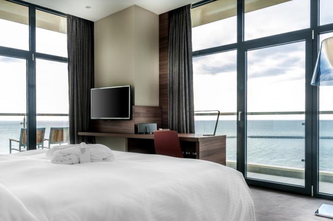 Панорамные окна с видом на море в номере отеля.