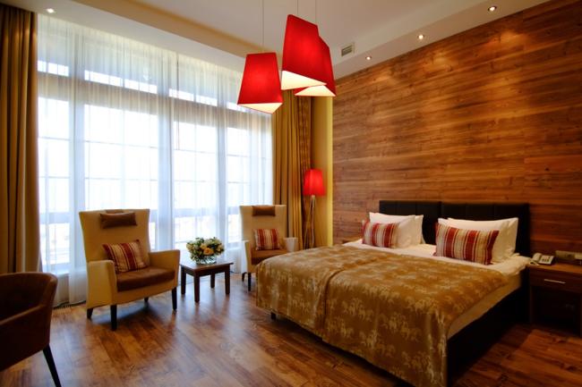 Две широкие кровати в номере с французскими окнами и красными абажурами.