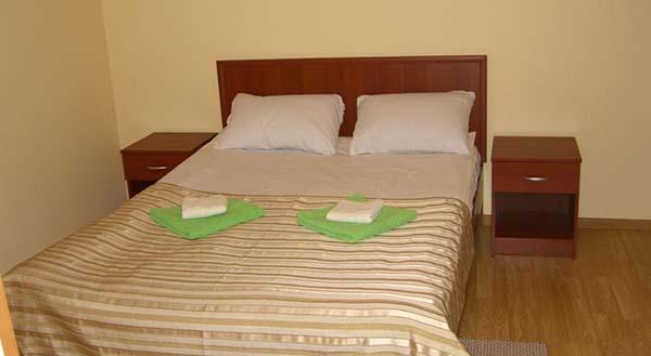 Двуспальная кровать в номере отеля.