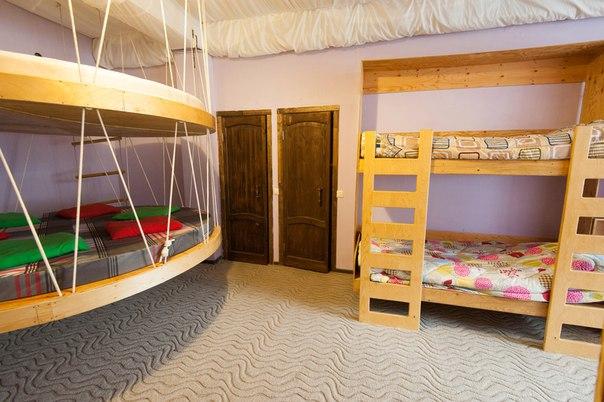 Комната с двухъярусными кроватями и круглой подвесной кроватью.